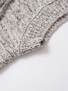 Close-up of gray knit fabric with intricate crochet patterns and textured weave detail