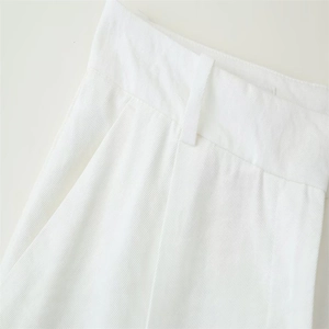 Close-up of white trousers featuring high-quality twill fabric and refined waist stitching