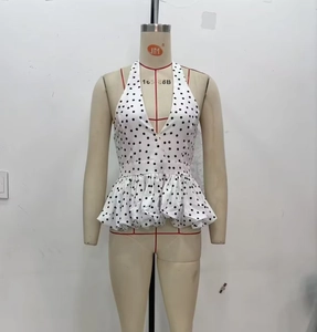 Detailed view of backless halter top with black polka dots and ruffle hem on a mannequin