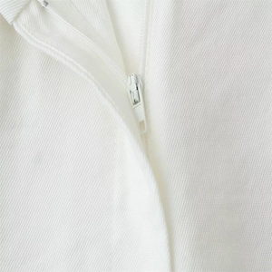 Close-up of invisible white zipper and twill fabric texture on a fashion jumpsuit