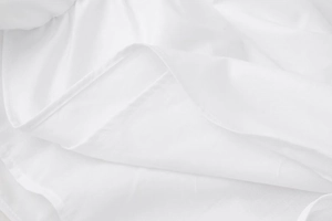 Detailed close-up of white chiffon fabric showing layered texture and neat hemline seams