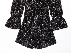 Detailed view of polka dot dress featuring elastic ruffled cuffs and layered chiffon hem