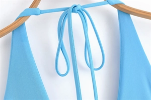 Detail of light blue halter neck dress with tie-up straps and fine knitted texture