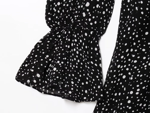 Detail of flared cuffs and elastic ruffled sleeves on a black polka dot chiffon dress