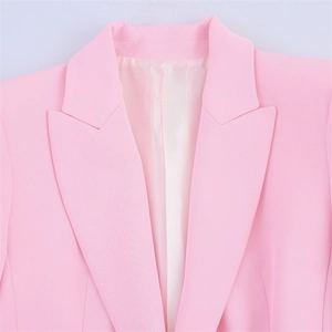 Detailed view of pink blazer notch lapel and shoulder tailoring with smooth fabric texture