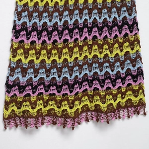 Colorful crochet knit top with wave patterns and handmade tassels on white background