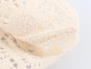 Close-up of beige crochet long sleeve top showing detailed openwork knitting texture