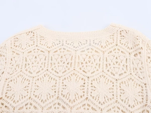 Close-up of cream crochet long sleeve top featuring intricate floral hollow knit details