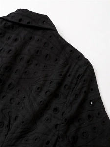 Détail de la broderie anglaise noire sur le col ajusté et l'épaule de la robe