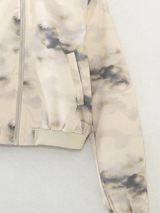 Detail of metal zipper and ribbed hem on a yellow tie-dye bomber jacket