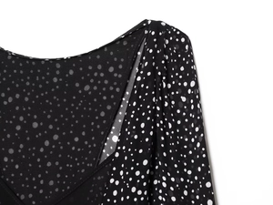 Macro detail of the pleated neckline on this black and white polka dot mini dress