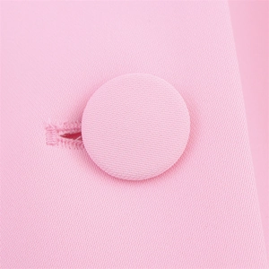 Detailed macro view of a pink fabric-covered button and twill texture on a blazer