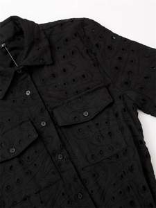 Détail de chemise en coton brodé noir avec col rabattu et doubles poches de poitrine