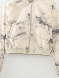 Close-up of marble print bomber jacket with metal zipper and ribbed elastic hemline