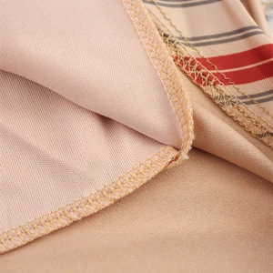 Close-up of beige dress with red and grey stripes showing high-quality stitching detail