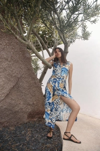 Detail of a bohemian sleeveless maxi dress with blue floral print and high side slit