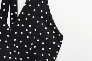 Detail of V-neckline on backless polka dot top with clean stitching and soft fabric