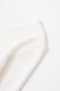 Macro detail of the fine ribbed knit texture and white stitching on a spring sweater