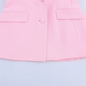 Detail of pink blazer with ostrich feather cuffs, flap pockets and matching button