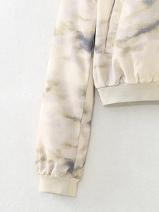 Detail view of rib-knit cuffs and tie-dye pattern on a women's lightweight bomber jacket