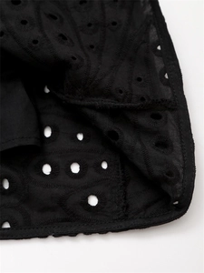 Détail du tissu noir en broderie anglaise avec des motifs de broderie ajourés complexes