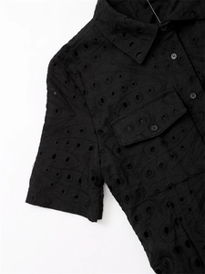 Détail de la broderie anglaise noire sur chemise à manches courtes avec poche cargo