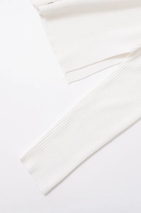Detailed macro view of ivory white ribbed knit texture on the sleeve cuff and hemline