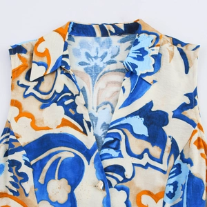 Detail of bohemian abstract floral print on a sleeveless shirt with a pointed collar