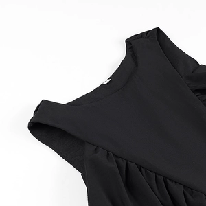 Close-up detail of pleated shoulder stitching and crew neck on a black minimalist top