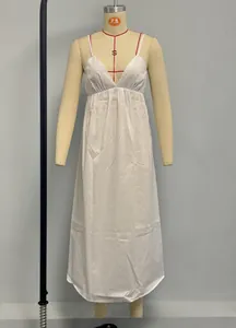 Detail of white V-neck maxi dress featuring spaghetti straps and a high waist design