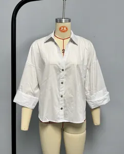 Detailed view of the lapel collar and button closure on white loose fit shirt