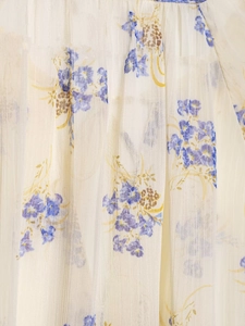 Close-up of semi-transparent floral chiffon fabric with delicate blue embroidery details
