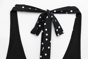 Detailed view of polka dot halter top featuring a retro bow tie and neck design