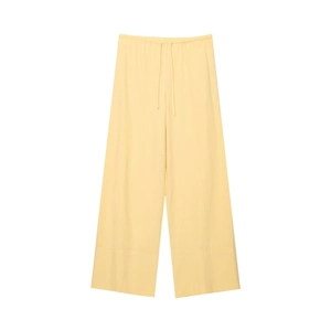 Dettaglio dei pantaloni in lino giallo chiaro a gamba larga con coulisse e orlo ampio