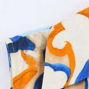 Close-up of high-quality sewing and vibrant abstract print fabric on summer dress