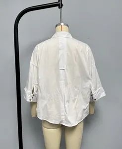 Detail of white cotton linen shirt showing back pleat and buttoned cuffs on a mannequin
