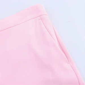 Detailed macro view of pink trousers waistline featuring a side pocket and fine stitching