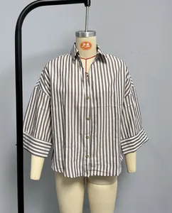 Detail of grey vertical striped blouse featuring lapel collar and golden buttons