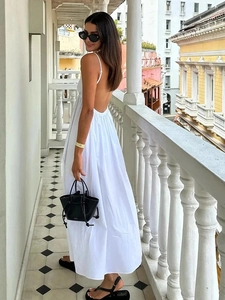 Detail view of the white backless maxi dress with thin straps and a high waist cut