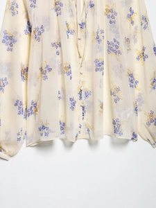Detail view of the floral print pattern and fabric texture on a long sleeve blouse