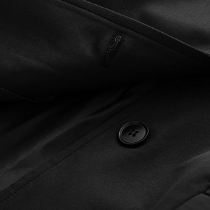 Close-up of black four-hole resin button on premium twill fabric blazer detail