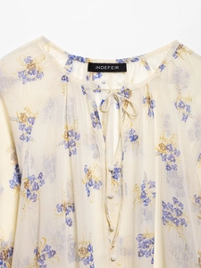 Close-up of lightweight floral chiffon blouse with drawstring neck and blue flower print