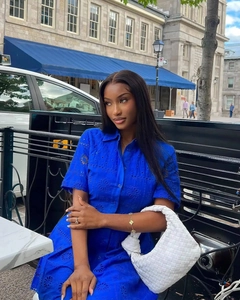 Close-up of bright blue shirt dress featuring delicate floral eyelet embroidery and buttons