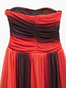 Detailed view of ruched mesh fabric on a strapless orange and brown summer dress