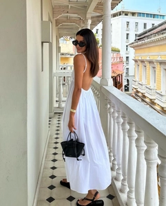Detail of elegant white backless maxi dress with thin straps and flowing hem design