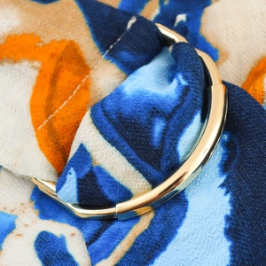 Close-up of golden metal buckle on colorful abstract print sleeveless summer dress