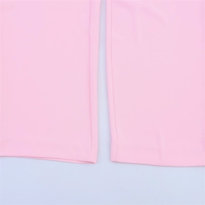 Detailed close-up of pink trousers hem with precise stitching and woven fabric texture