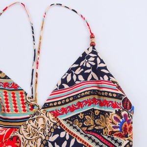 Detail of bohemian print V-neck dress with ethnic patterns and wooden beads