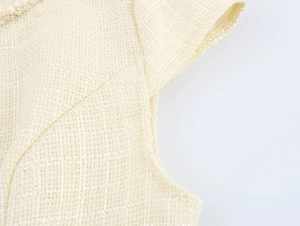 Vue macro détaillée de la texture du tweed beige et de la bordure tressée de la robe chic