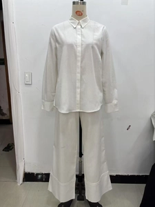 Détail d'un ensemble blanc deux pièces avec chemise texturée et pantalon large pour femmes